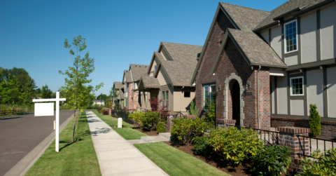 Photo of house from sidewalk view with for sale sign out front
