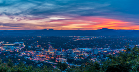 sunset over city with mountains in background
