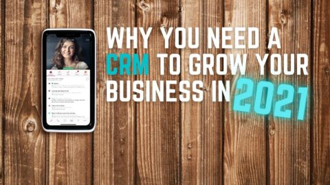 Wooden background with phone and text saying "why you need a CRM to grow your business in 2021"