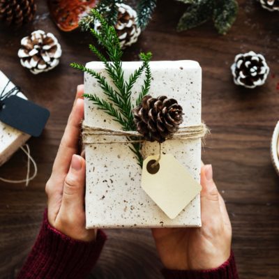 present wrapped with white paper and pinecone