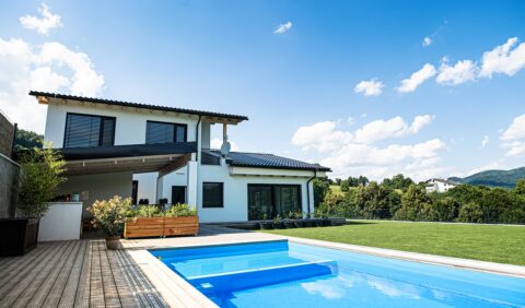 exterior of house and backyard with swimming pool on a sunny day