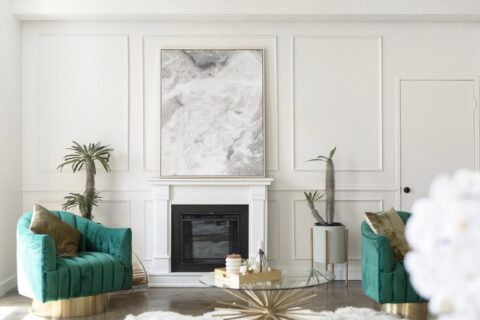 Modern bright interior living room with fireplace and green accent furniture